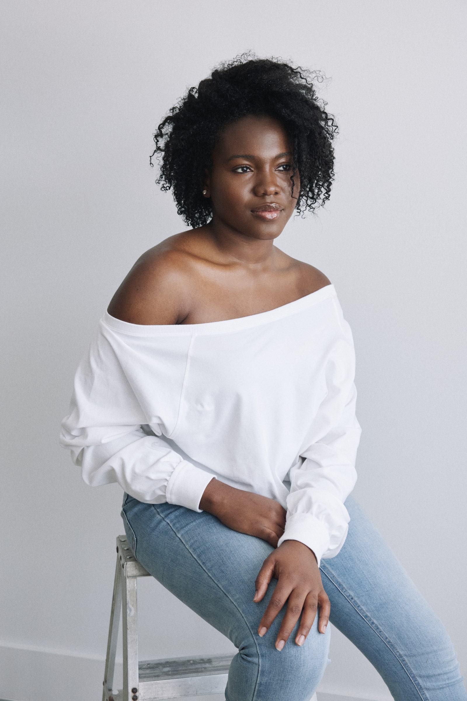 Portrait of Treicy Saint Jean wearing a white off-the-shoulder top